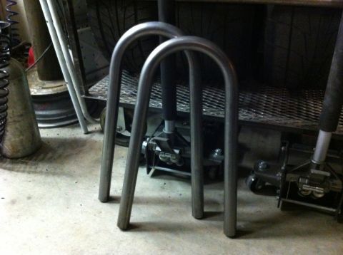 1987 Suzuki Samurai - Two metal U-shaped tubes are shown on a concrete floor, possibly for a vehicle suspension modification.