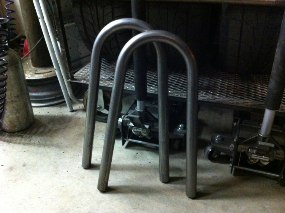Two metal U-shaped tubes on a concrete floor