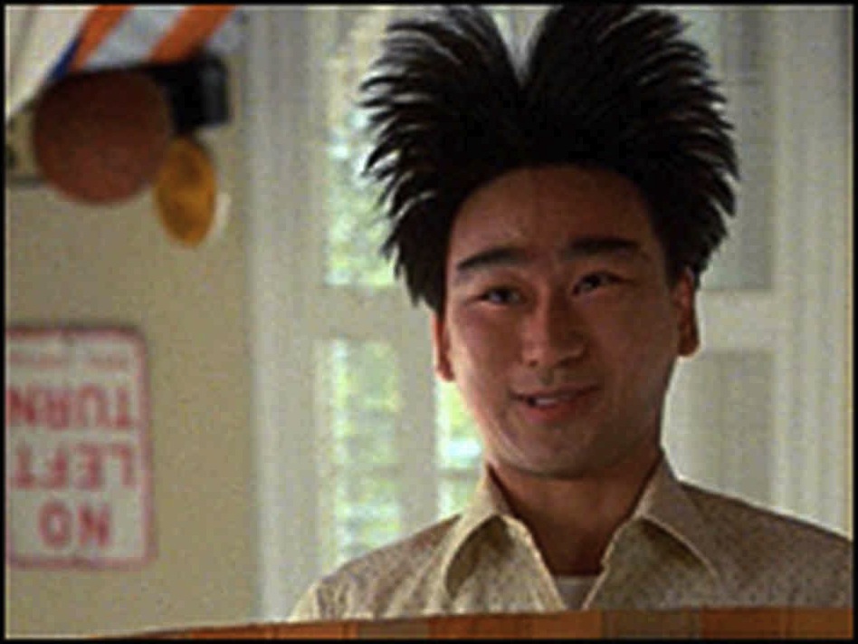 Man with spiky hair and a "No Left Turn" sign