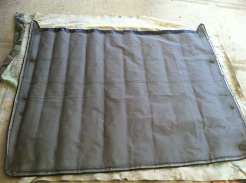1990 Ford Bronco - A padded canvas top, likely for a convertible or Jeep, is shown laid out on a surface.
