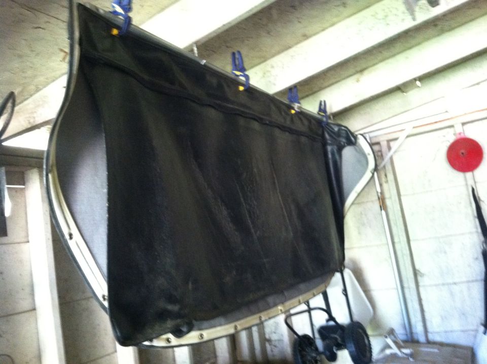 Black car door panel with white trim hanging from clips