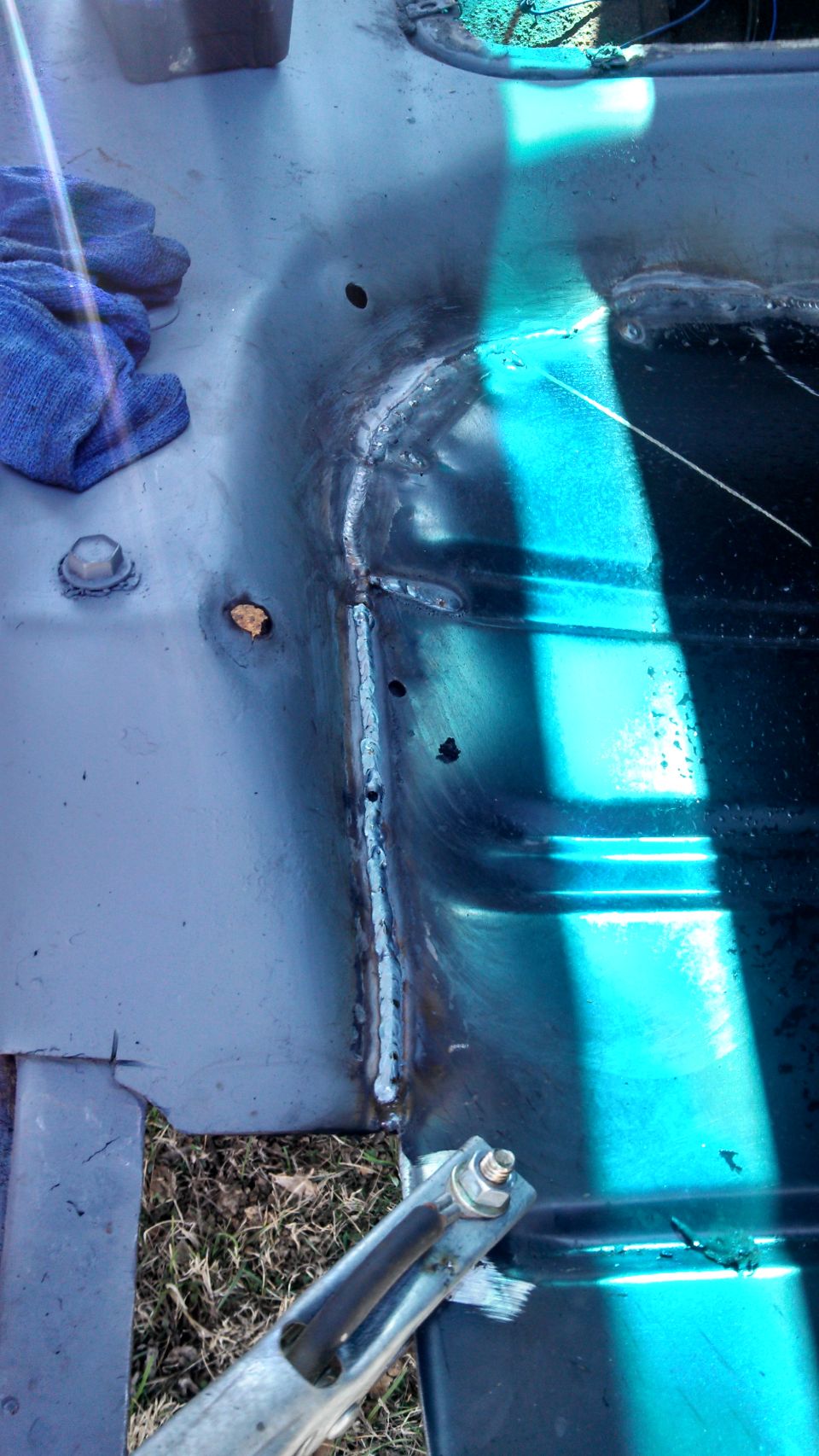 Welded metal panel with blue cloth and bolt assembly