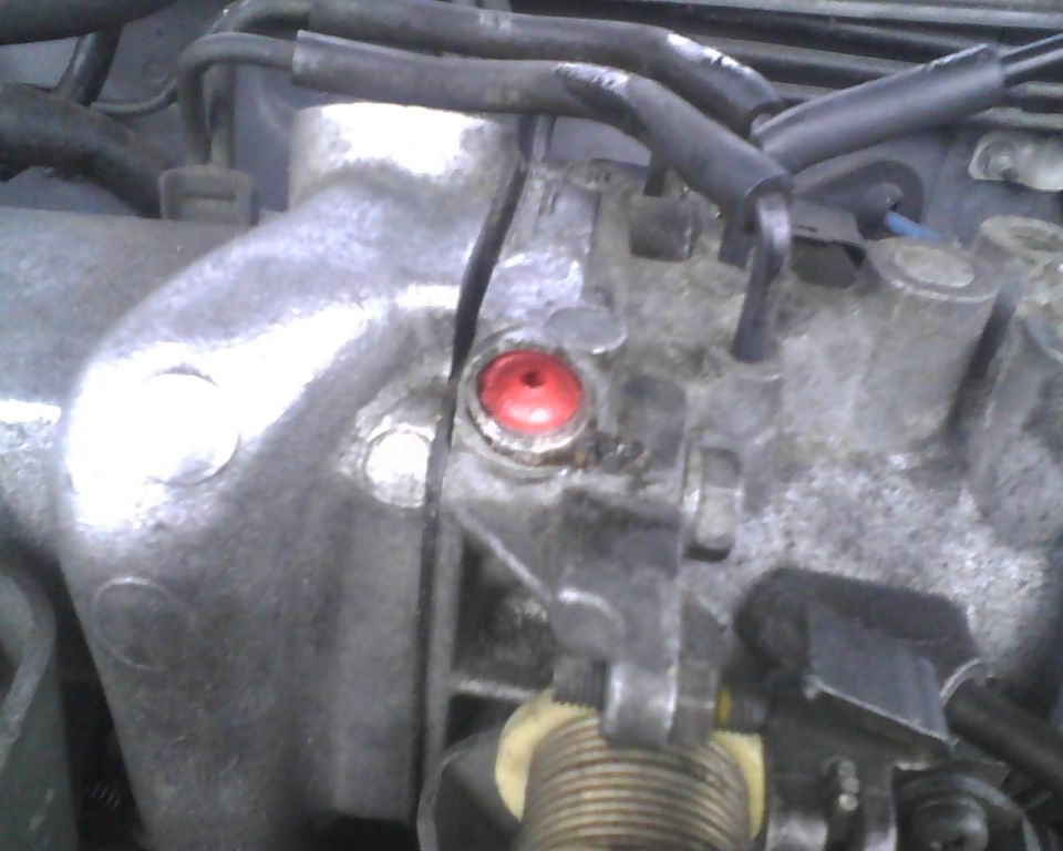 Close-up of a car's engine throttle body with a red cap