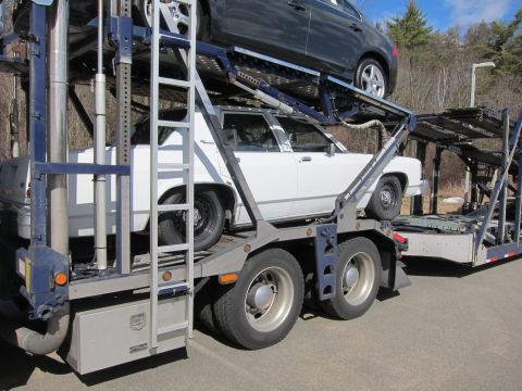 1991 Ford LTD Crown Victoria - White 1991 Ford Crown Victoria LTD loaded onto a car carrier with another vehicle above it.