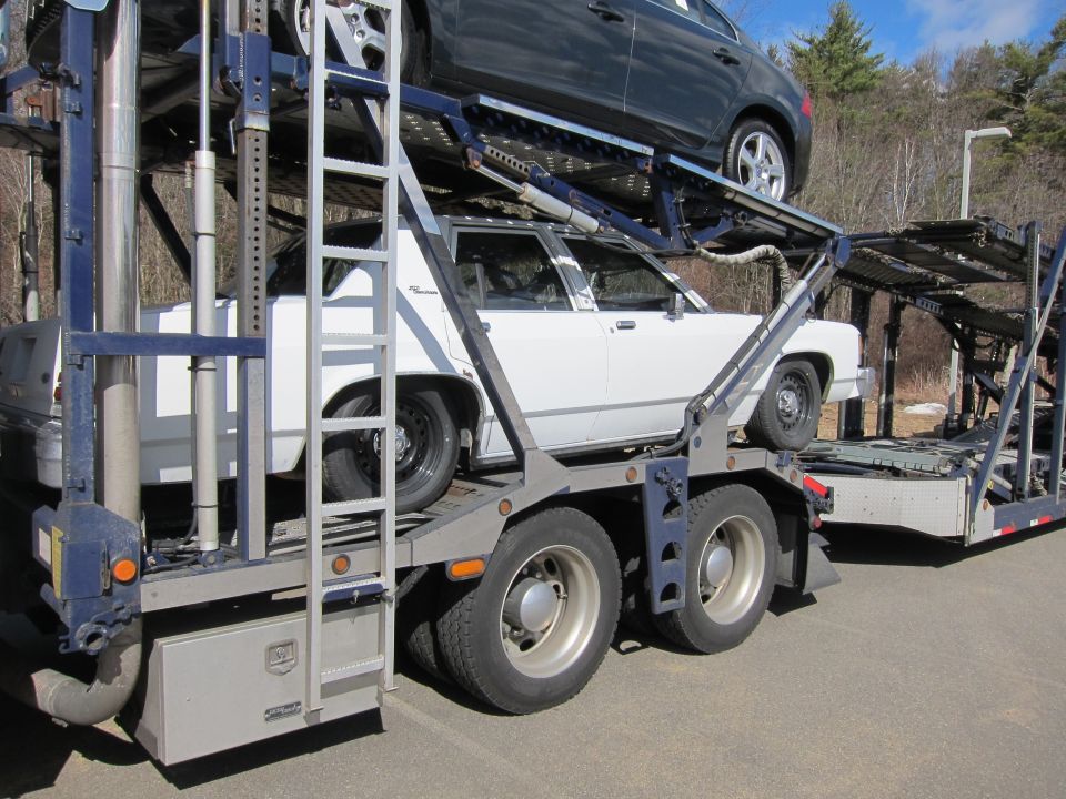 1991 Ford Crown Victoria LTD on car carrier, side view. Another car is on the upper deck