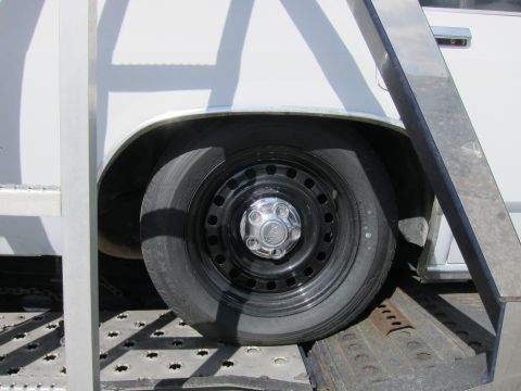 1991 Ford LTD Crown Victoria - The rear wheel and fender of a vehicle are visible, mounted on a trailer.