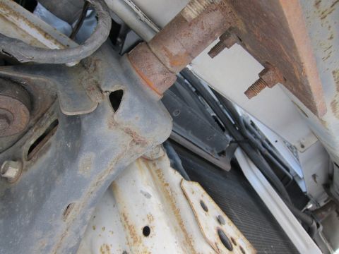 1991 Ford LTD Crown Victoria - Close-up of rusted automotive bracketry and radiator components.