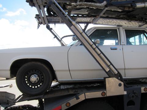 1991 Ford LTD Crown Victoria - A white 1991 Ford Crown Victoria LTD is seen being transported on a car carrier.