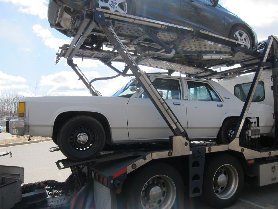 1991 Ford Crown Victoria LTD on car carrier, side view. Another car is on the upper deck