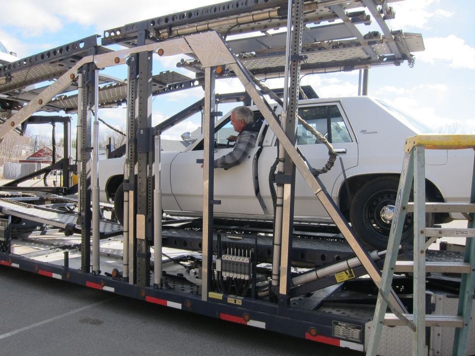 White 1991 Ford Crown Victoria LTD on a car carrier, side view