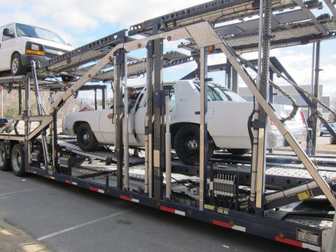 1991 Ford LTD Crown Victoria - White 1991 Ford Crown Victoria LTD loaded onto a car carrier with a van above it.