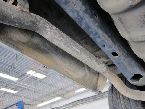 1991 Ford LTD Crown Victoria - Underside view of a vehicle's frame and exhaust system, showing signs of rust and wear.