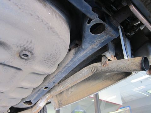 1991 Ford LTD Crown Victoria - The undercarriage of a vehicle shows the fuel tank and exhaust system components.