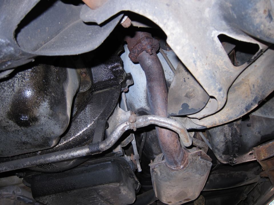 Underside view of a vehicle's exhaust pipe and oil pan