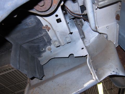 1991 Ford LTD Crown Victoria - Close-up view of a front bumper bracket and associated wiring, showing structural components and some rust.