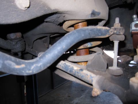 1991 Ford LTD Crown Victoria - The front suspension system of a vehicle, showing the sway bar, coil spring, and other mechanical parts.