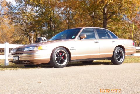 1993 Ford Crown Victoria - Modified 1993 Ford Crown Victoria sedan with a prominent hood scoop and custom wheels.