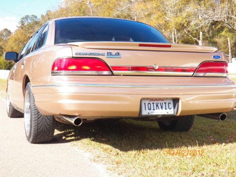 1993 Ford Crown Victoria - Rear view of a gold sedan, identified by its 'Crown Victoria 5.4' badge.
