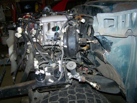 1988 Suzuki Samurai - The engine bay of a vehicle is shown with various mechanical components and wiring.