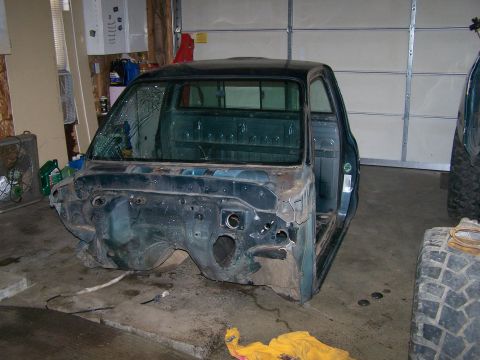 1988 Suzuki Samurai - This truck cab is missing its front end and has a cracked windshield, with the driver's door open.