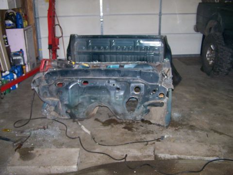 1988 Suzuki Samurai - The front section of a vehicle chassis and bed is shown in a garage setting.