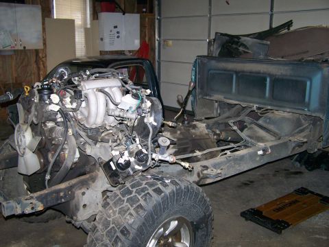 1988 Suzuki Samurai - This image shows the engine bay of a truck with the engine removed, revealing the chassis and transmission components.