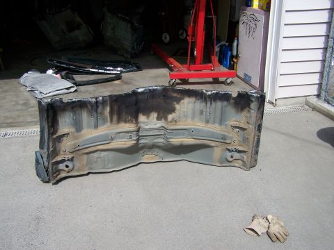 1988 Suzuki Samurai - A disassembled vehicle chassis part sits on the ground, with an engine hoist visible in the background.