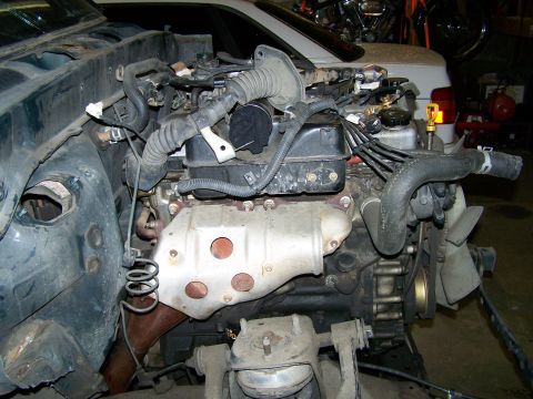1988 Suzuki Samurai - Vehicle engine bay with engine components visible, including hoses and wiring.