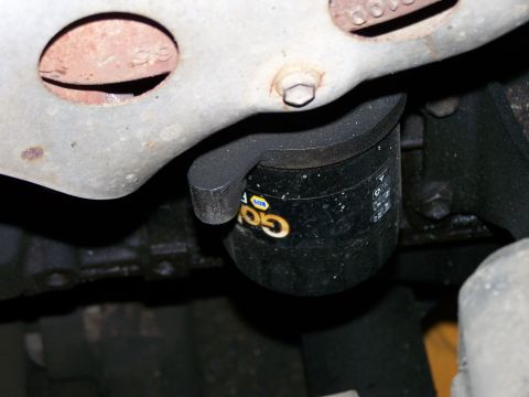 1988 Suzuki Samurai - A close-up view of a vehicle's oil filter and a section of the exhaust system.
