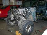 1988 Suzuki Samurai - A vehicle's front end is disassembled, revealing the engine and chassis in a garage setting.