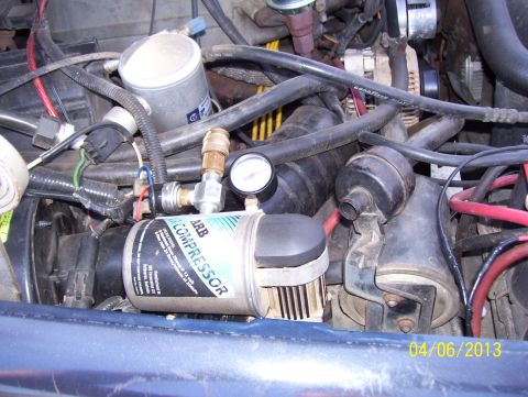 1990 Ford Bronco - Close-up of an ARB air compressor installed among engine components.