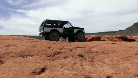 1994 Ford Bronco - This 1994 Ford Bronco is parked on a rocky desert terrain with its doors open.