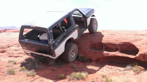 1994 Ford Bronco - This Ford Bronco is navigating a rocky desert terrain with its doors open.