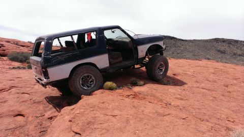 1994 Ford Bronco - This modified SUV is navigating a rocky, desert terrain.
