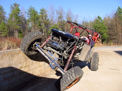 1994 Ford Bronco - This heavily modified buggy is tackling an obstacle, with its front tire high on the wall.