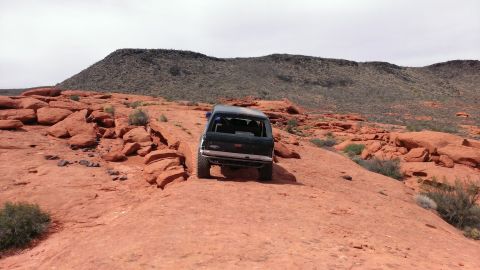 1994 Ford Bronco - 1994 Ford Bronco navigates a rocky desert path.
