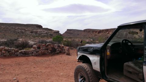 1994 Ford Bronco - Side view of a 1994 Ford Bronco in a desert landscape with stone ruins.