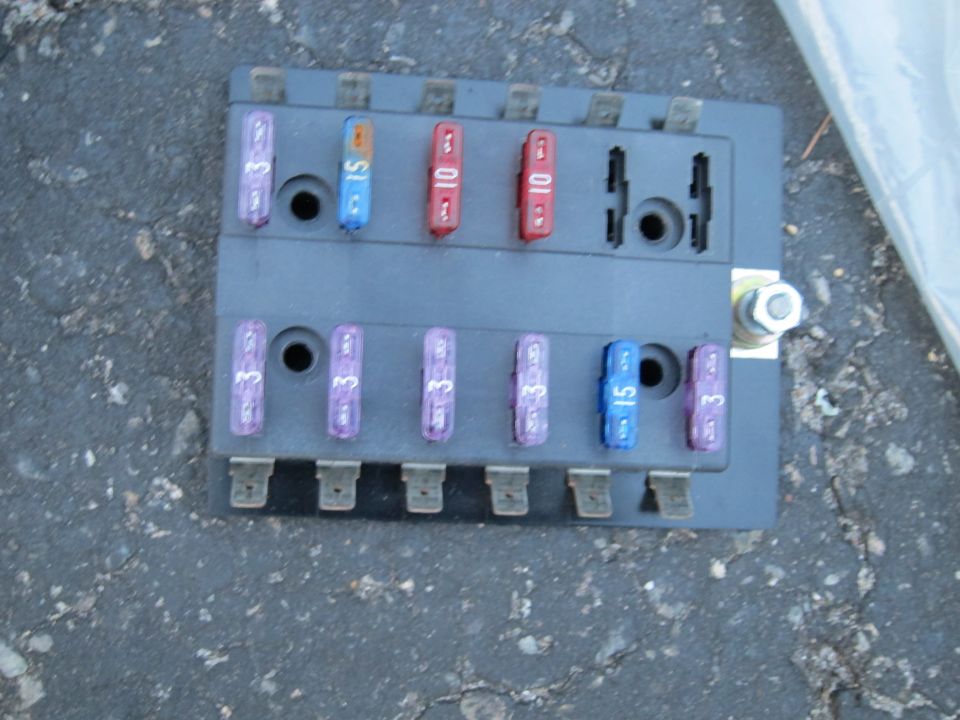 Automotive fuse box with several fuses installed, some labeled 3, 10, and 15