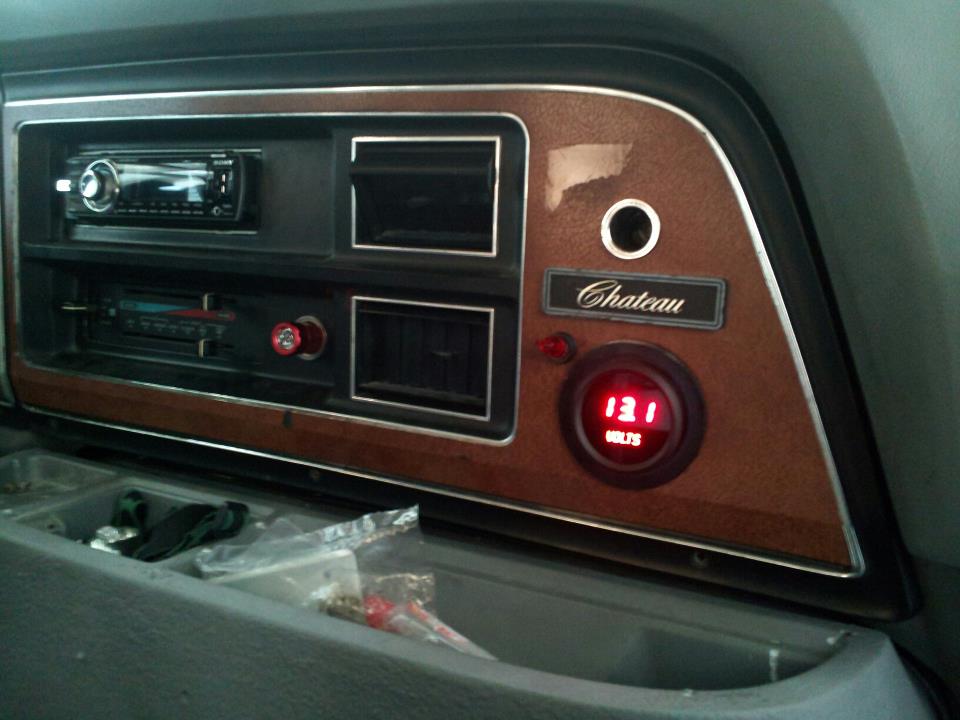 Dashboard with two radios, air vents, and a 'Chateau' emblem above a red digital voltage meter showing 13.1 volts