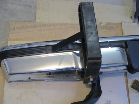 1991 Ford LTD Crown Victoria - Close-up of a chrome bumper with a black step assembly, likely a vehicle part.