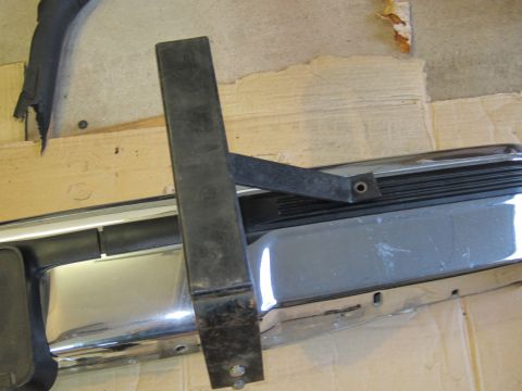 1991 Ford LTD Crown Victoria - Close-up of a chrome bumper section with a black metal bracket bolted on.