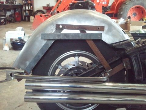 1995 Ford F-150 - The rear section of a motorcycle is shown, focusing on the fender, wheel, and exhaust system with visible metalwork.
