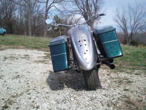 1995 Ford F-150 - This motorcycle is parked on a gravel surface with trees in the background. A website watermark is visible in the lower right corner.