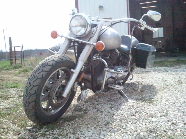 Front view of a silver motorcycle with chrome accents and black saddlebags