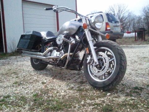 1995 Ford F-150 - Custom motorcycle with saddlebags and chrome exhaust parked on gravel in front of a garage.
