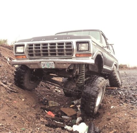 1979 Ford Bronco - This modified Ford Bronco is shown at an angle on a dirt path, with its suspension clearly visible.