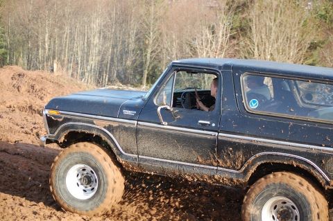 1979 Ford Bronco - This classic Ford Bronco navigates a muddy trail, its off-road capabilities.