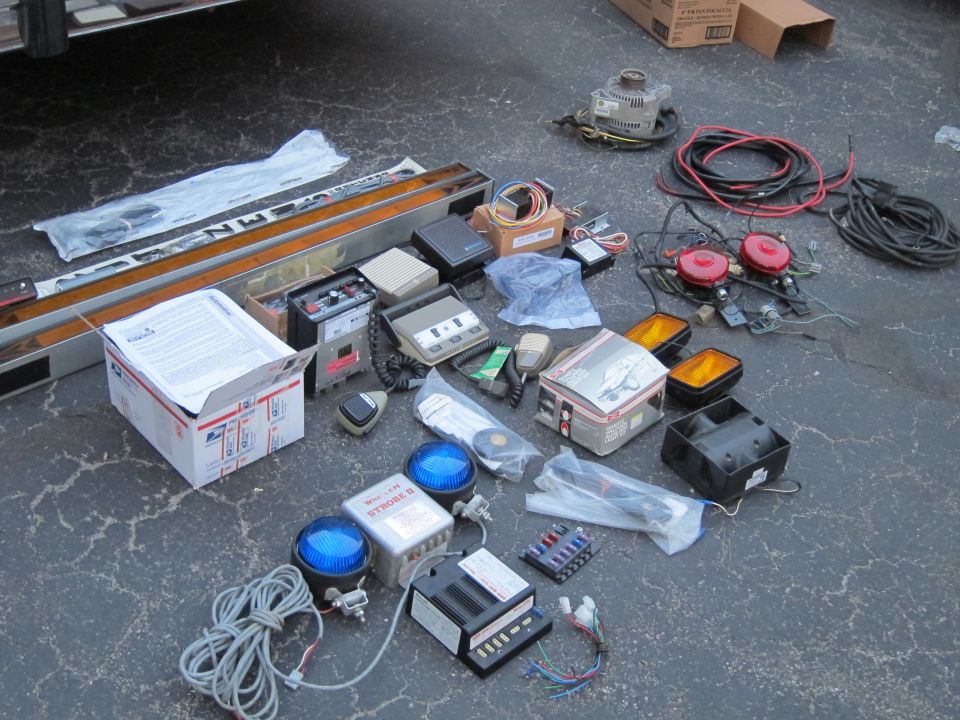 Assorted police car equipment including lights, sirens, and wiring
