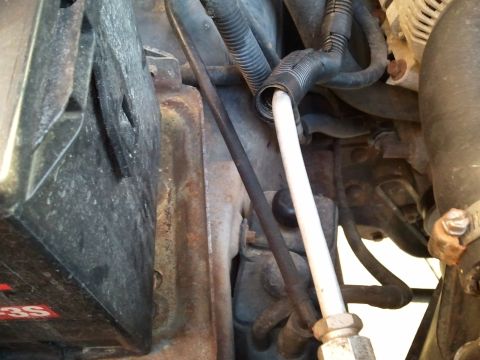 1994 Ford Bronco - Close-up view of engine components including a battery and various hoses and wiring.