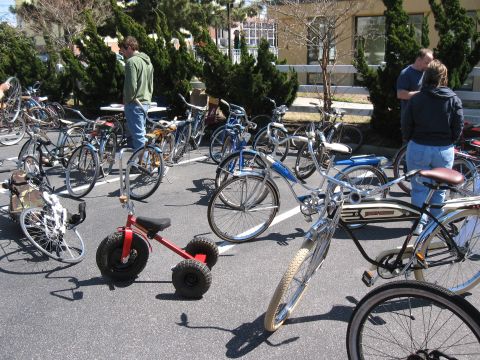 1994 Ford Bronco - An assortment of bicycles and a tricycle are gathered outdoors, with several people observing them.